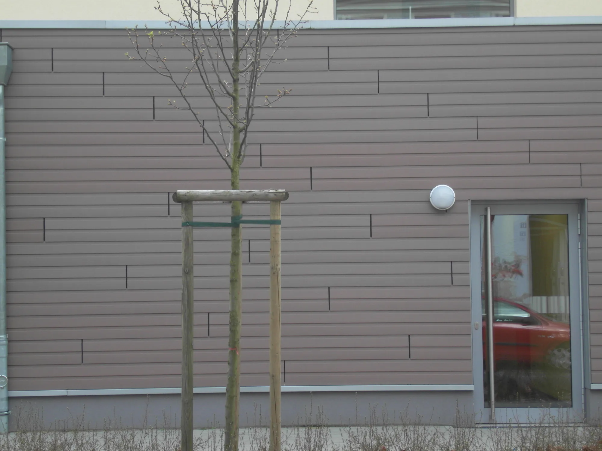 Fertige WPC-Fassade der Kita Dortmund mit sauber eingebundenem Türanschluss Fertige WPC-Fassade der Kita Dortmund mit sauber eingebundenem Türanschluss