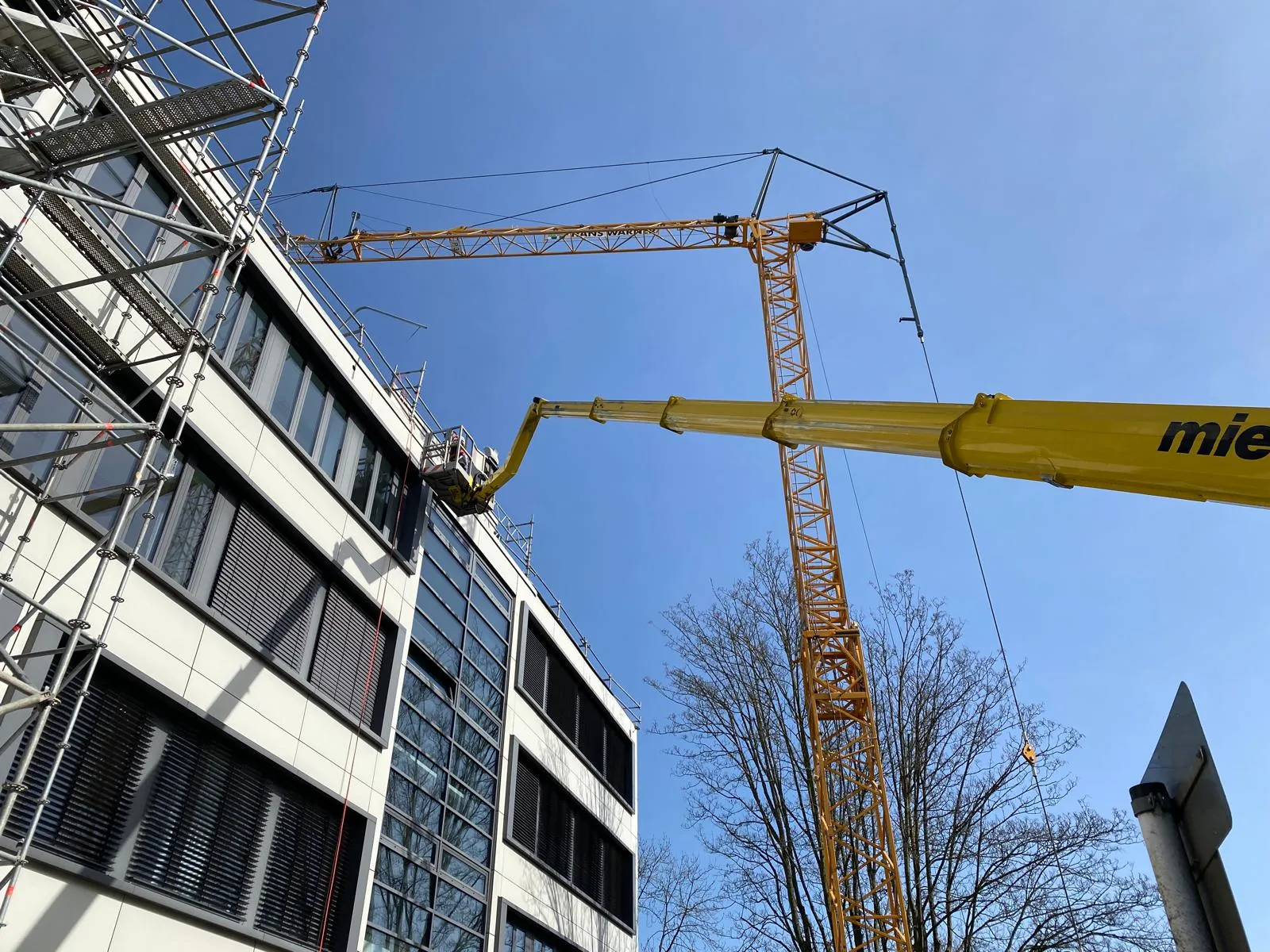 Hubarbeitsbühne im Einsatz an einer Fassade, Kranvermietung von Hamacher Bedachungen