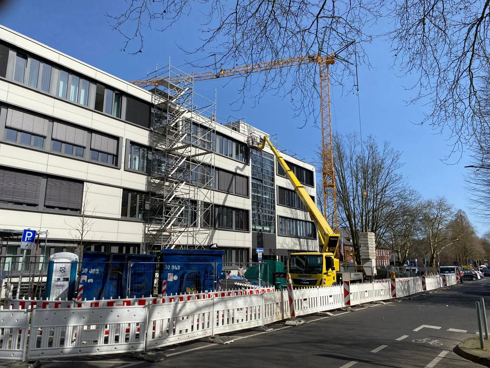 Innerstädtische Kranlogistik mit Turmdrehkran bei Dacharbeiten von Hamacher Bedachungen