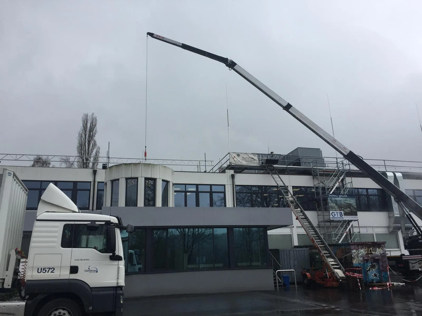 Mobilkran beim Materialtransport auf das Dach, Kranarbeiten von Hamacher Bedachungen