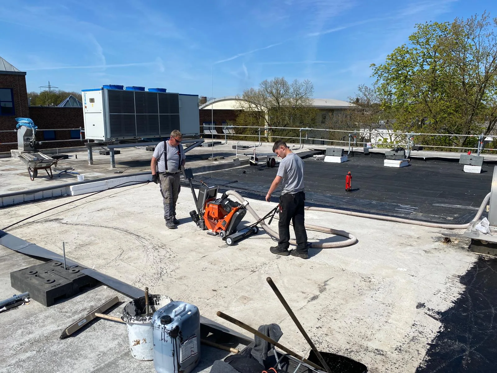 Kugelstrahlen des Betonuntergrunds auf einem Flachdach durch Mitarbeiter von Hamacher Bedachungen in Mönchengladbach Kugelstrahlen des Betonuntergrunds auf einem Flachdach durch Mitarbeiter von Hamacher Bedachungen in Mönchengladbach