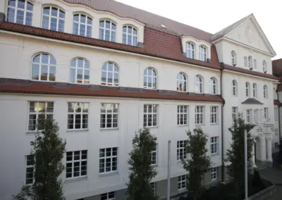 Innenhoffassade des Maria-Lenssen-Berufskollegs mit Mansarddach, Gauben und roter Ziegeldeckung